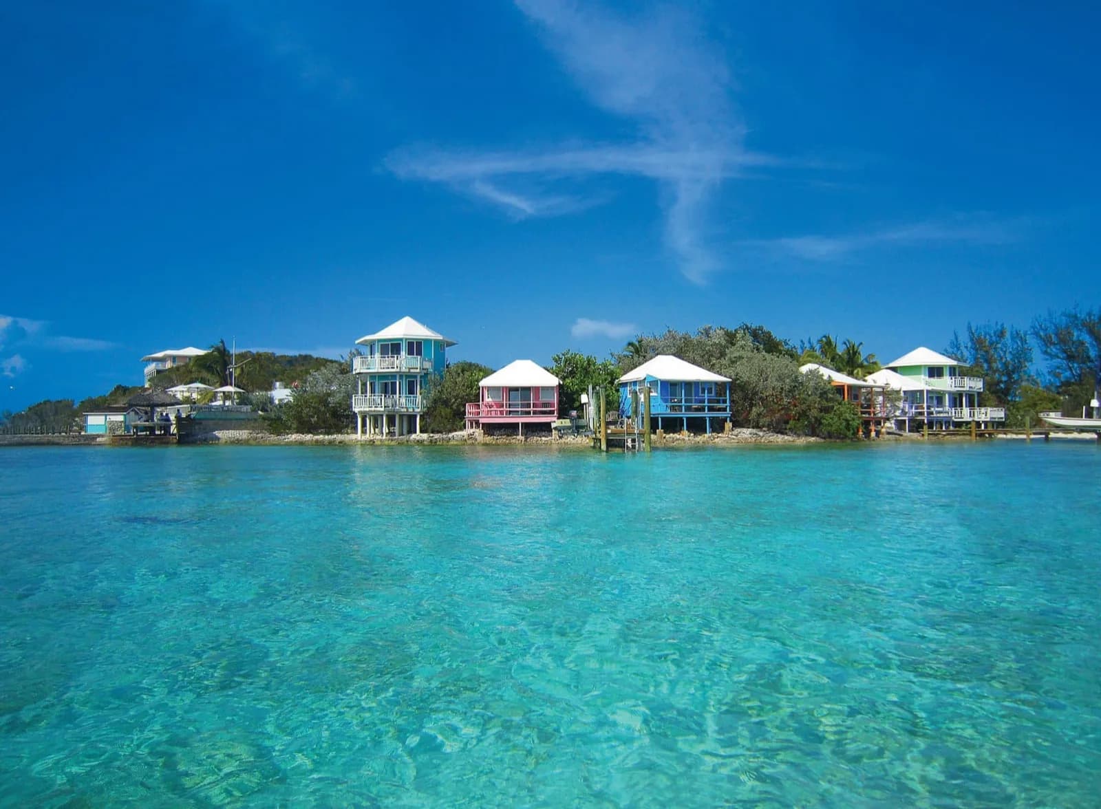 Die bunten Bungalows des Staniel Cay Yacht Club über dem klaren Wasser