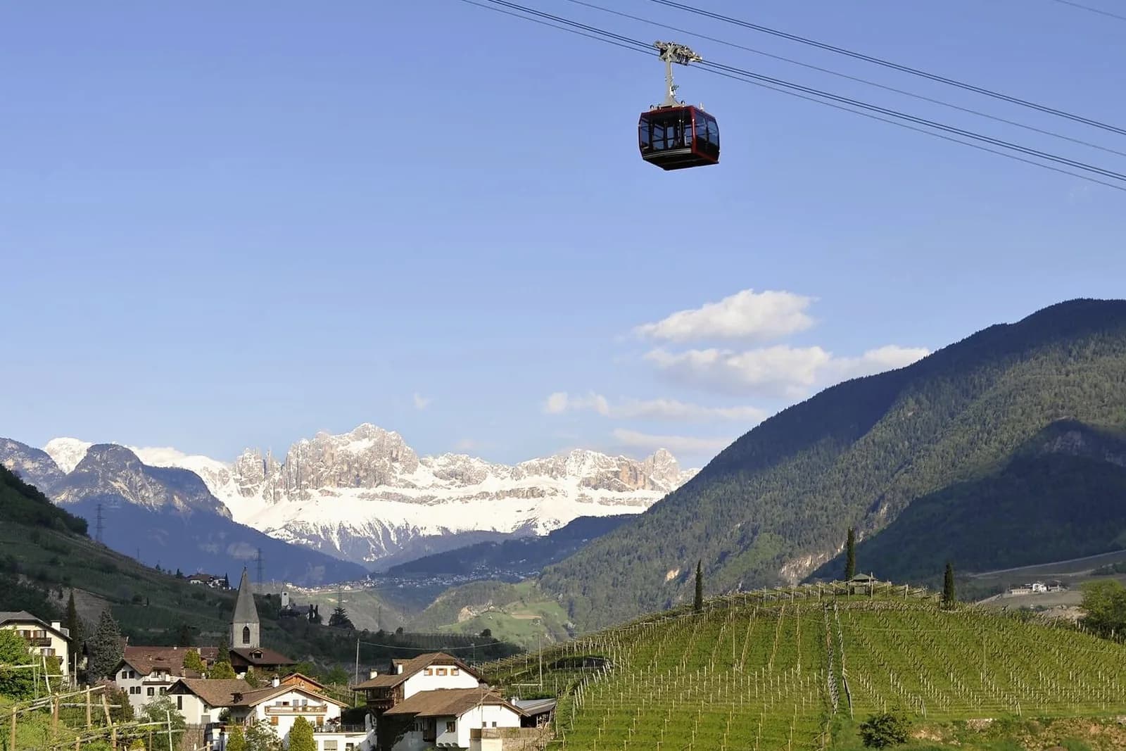Gondel der Rittner Seilbahn über den Weinbergen, dahinter der Rosengarten
