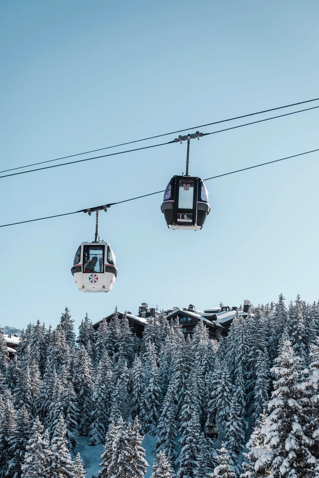 Gondeln über verschneiten Tannen in Courchevel