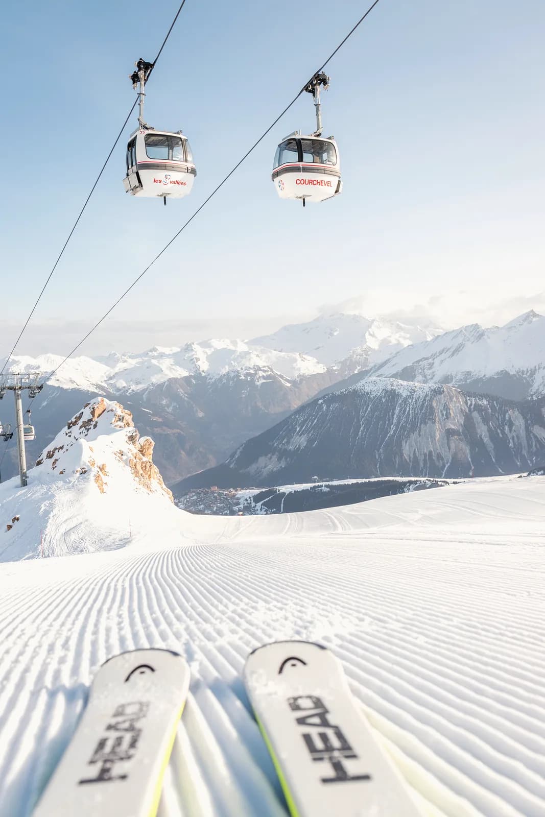 Blick über die eigenen Skier auf frisch präparierte Piste und Gondeln