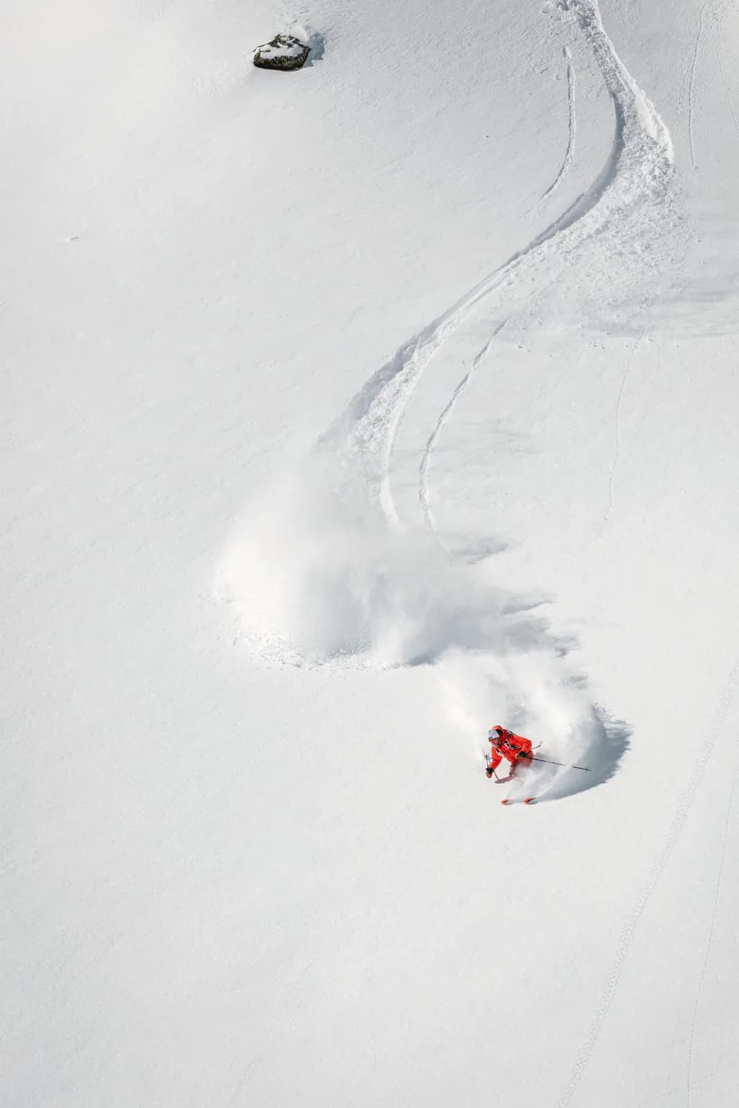 Einzelner Skifahrer zieht eine Spur durch unberührten Tiefschnee