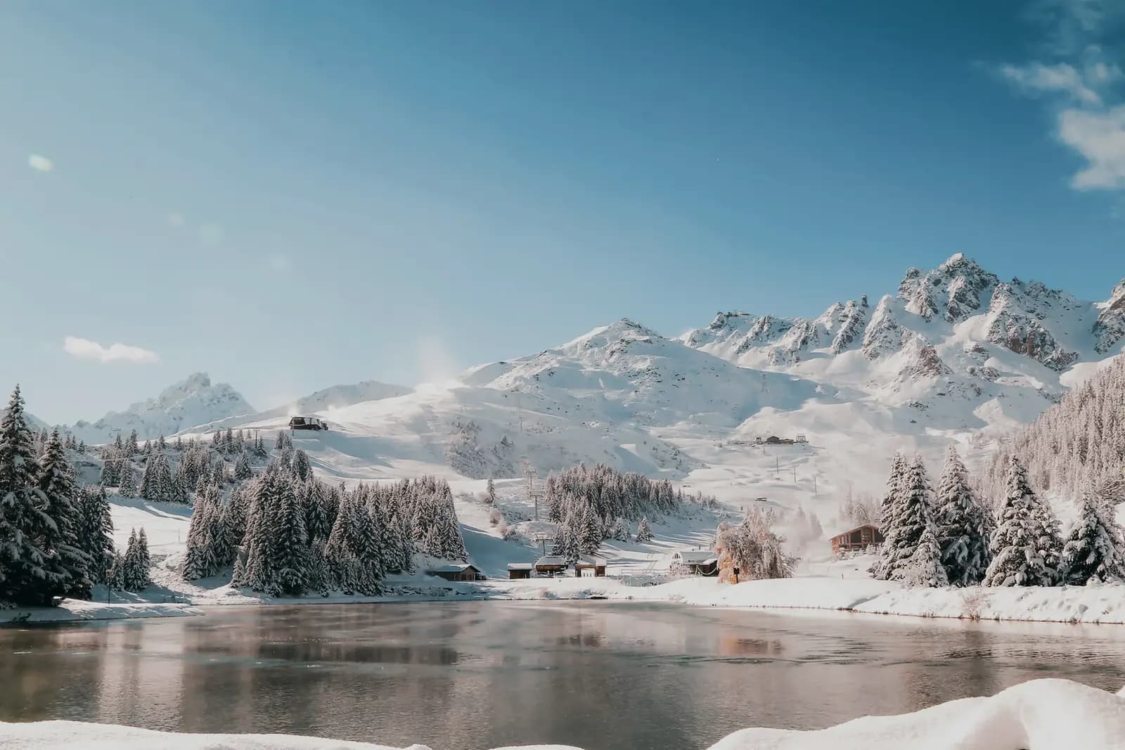 Verschneiter See vor dem Bergpanorama von Courchevel