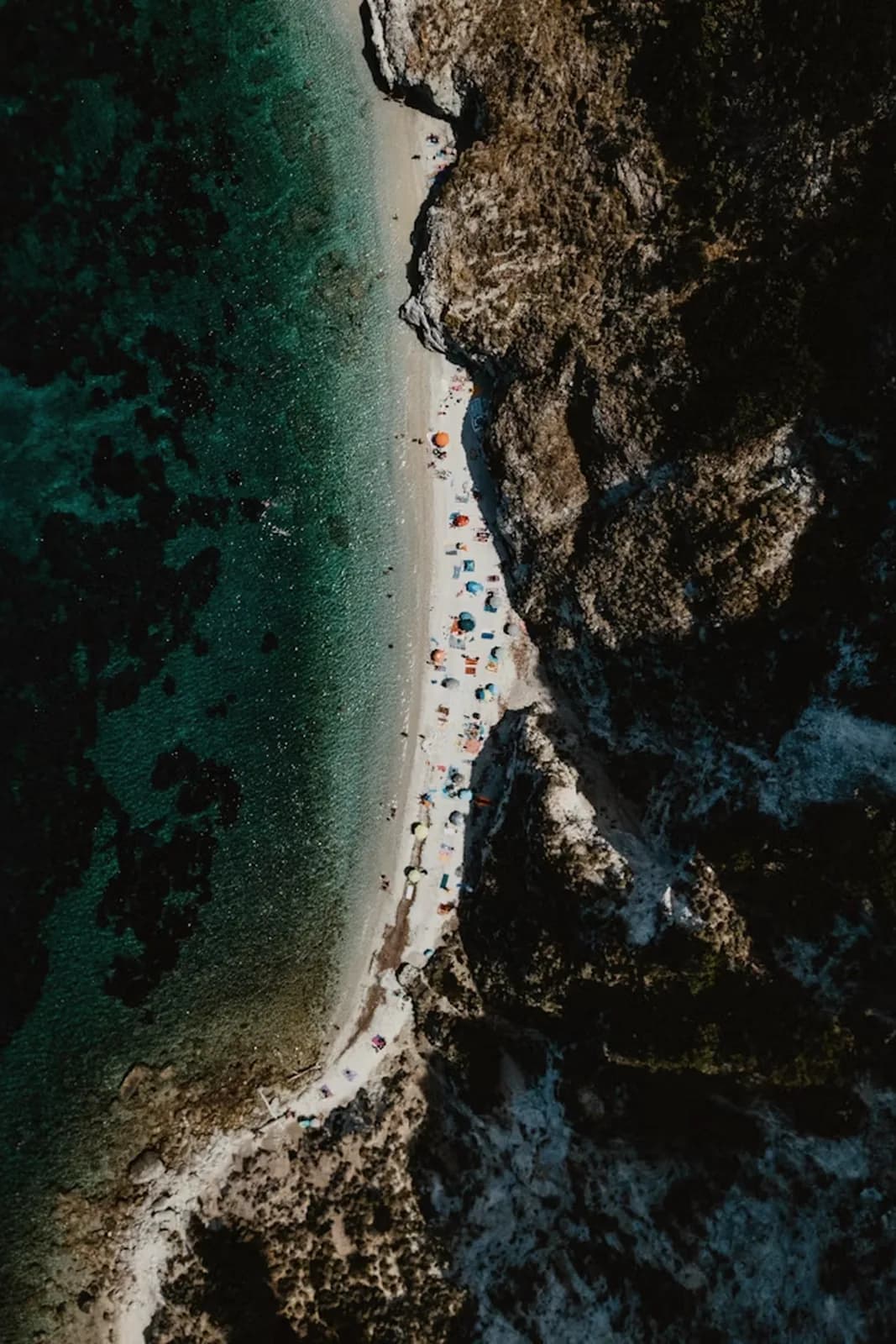 Schmaler Strand zwischen Felsen von oben