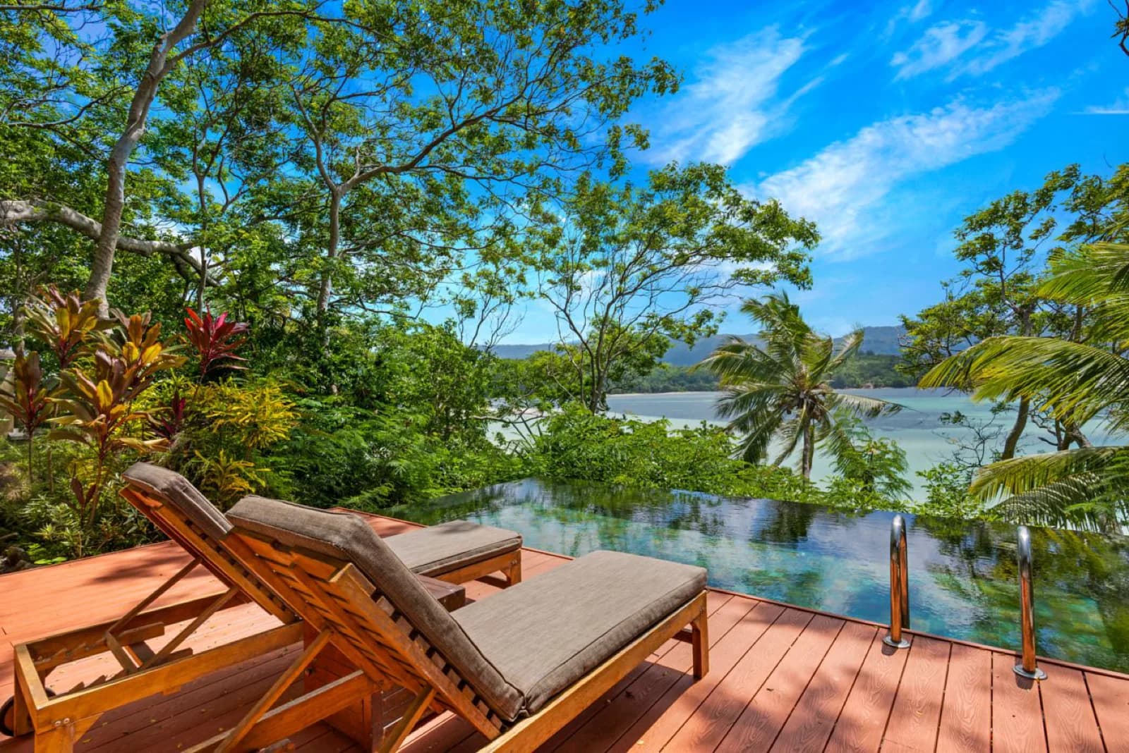 Enchanted Island Resort – Pool und Liegen über dem Meer