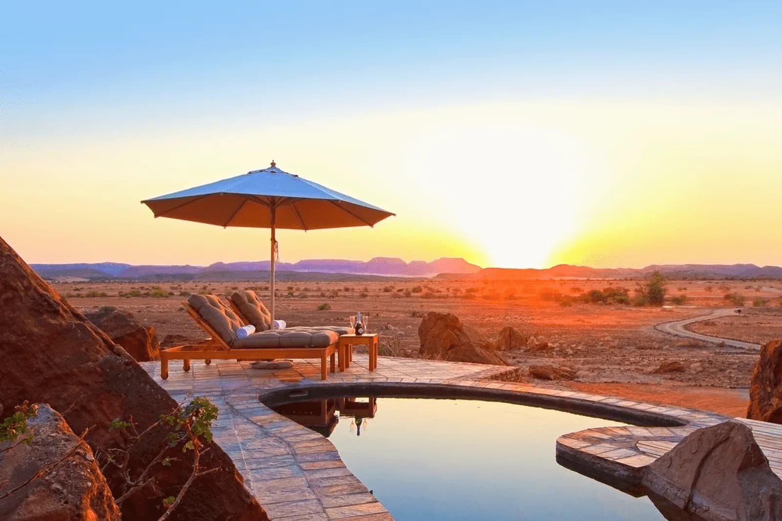 Twyfelfontein Country Lodge – Pool im Abendlicht über der Ebene