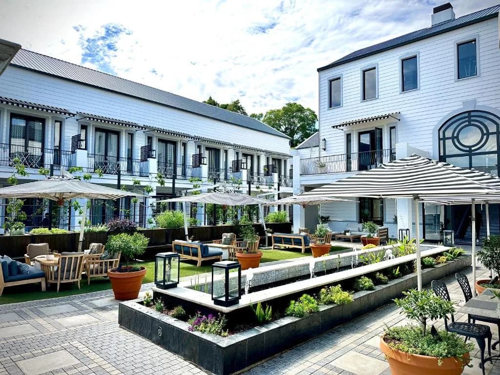Begrünter Innenhof mit Sonnenschirmen und Loungemöbeln