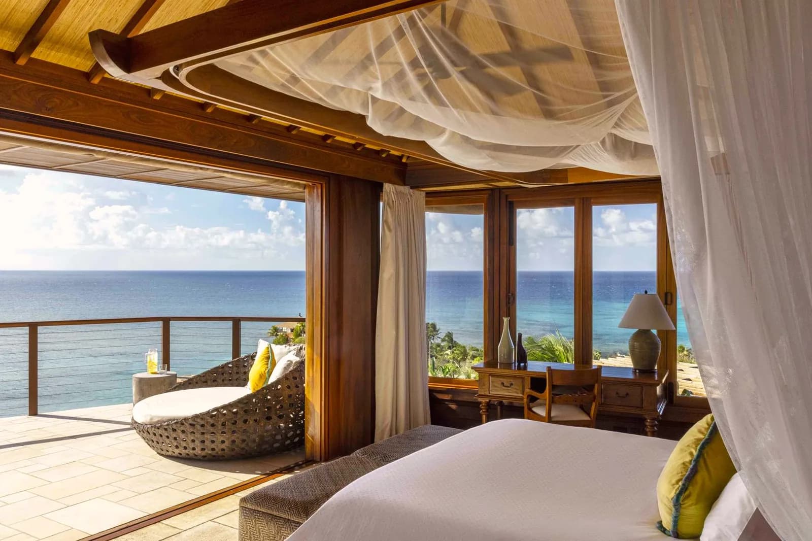 Schlafzimmer mit Moskitonetz und offenem Blick auf das Karibische Meer