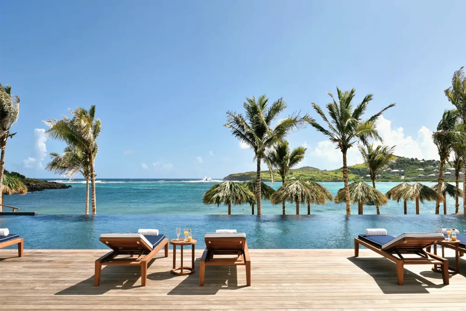 Infinity-Pool mit Liegen und Blick über die Lagune