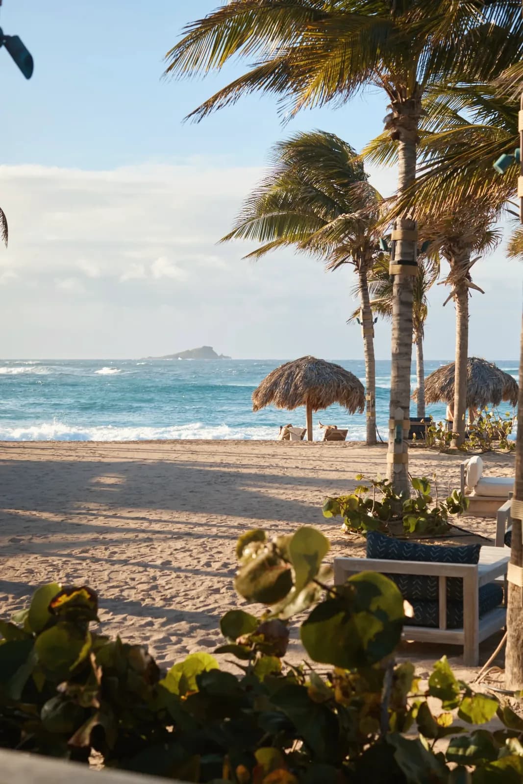Strand mit Palmen und Sonnenschirmen vor dem Rosewood Le Guanahani