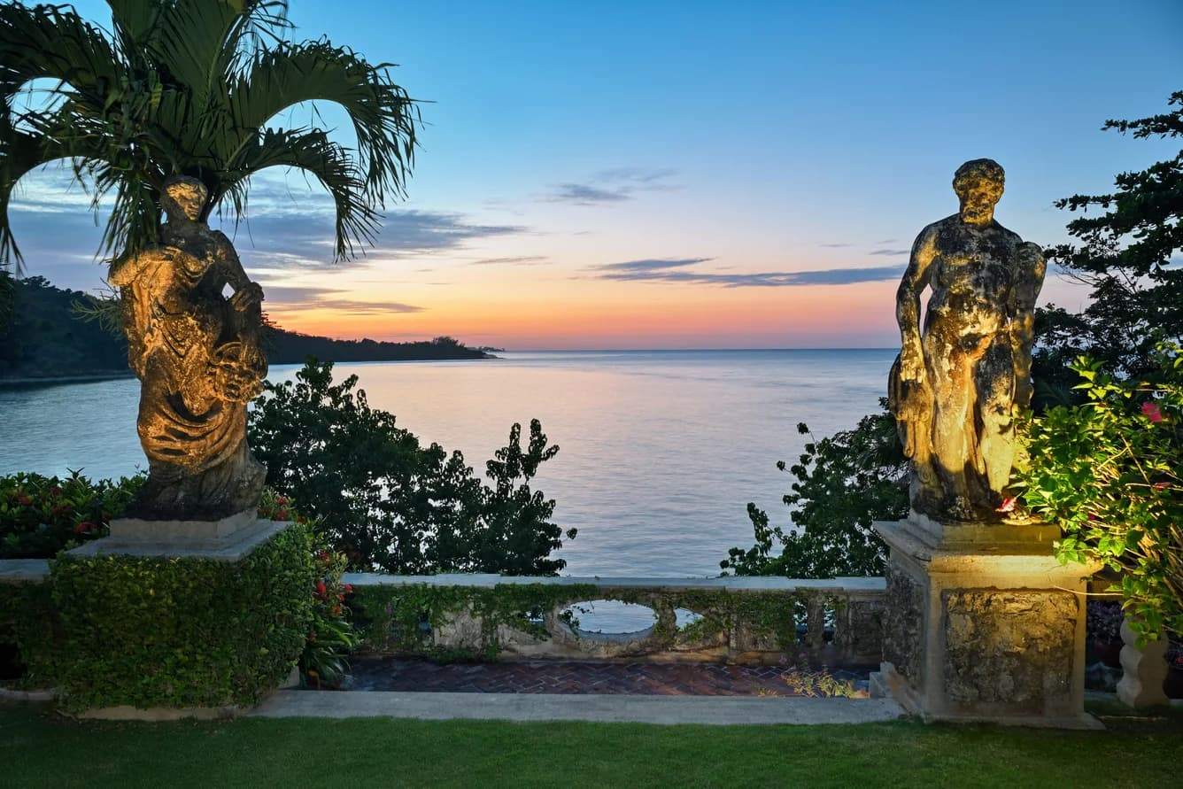 Garten mit Statuen im Abendlicht über dem Meer