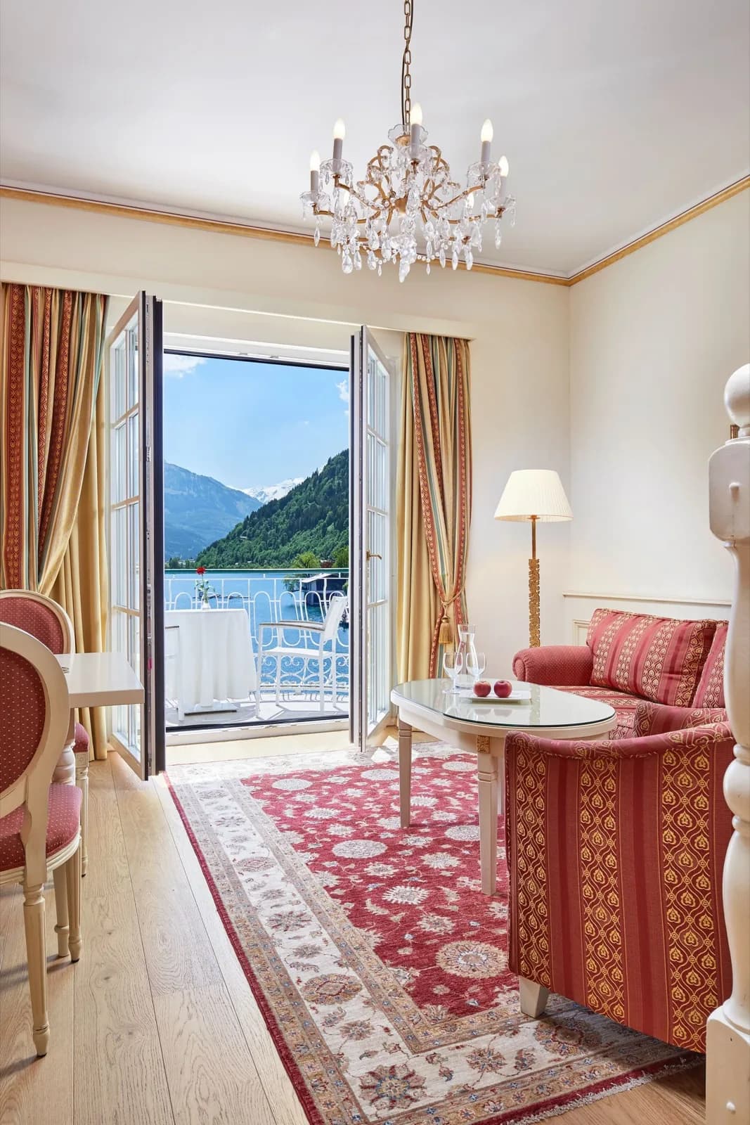 Grandhotel Zell am See – Wohnbereich mit Kristalllüster und offener Balkontür